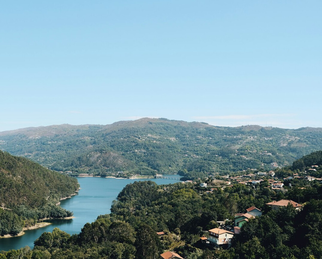 Aerial view of a Portuguese river winding through green hills near industrial land
